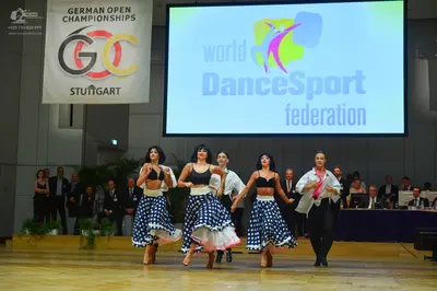 Dancesport competitor: Three female dancers: black bra tops and blue and white polka dot skirts with wh