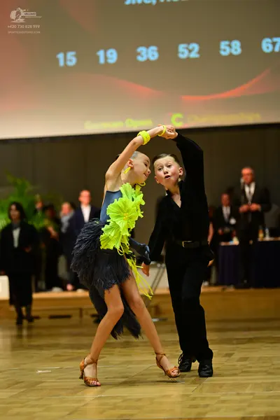Dancesport competitor: Female dancer: dark blue Latin dress with bright lime green ruffles at the waist