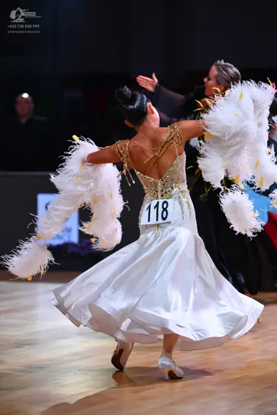 Dancesport competitor: Female dancer: white ballgown with a sequined bodice and large, fluffy white fea