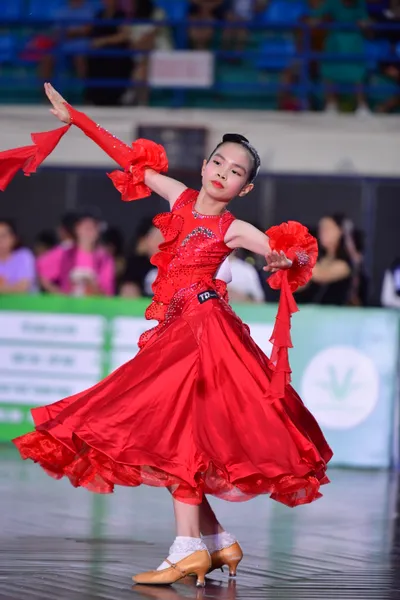 Dancesport competitor: ** Female: Red Latin dress with ruffled, flowing sleeves and a full, voluminous 