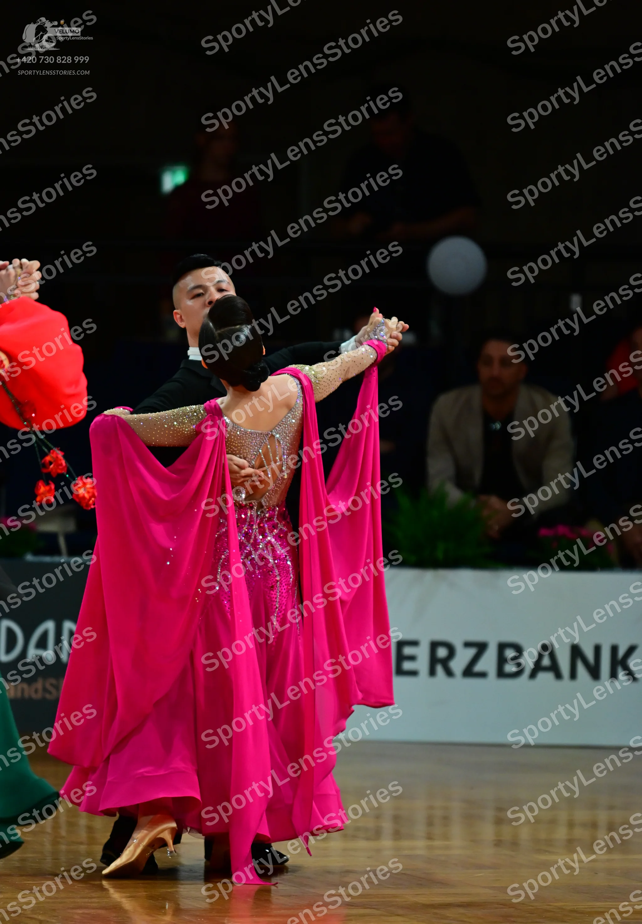 Dancesport competitor: Female dancer: bright pink ballroom gown with a sequined bodice, sheer back pane