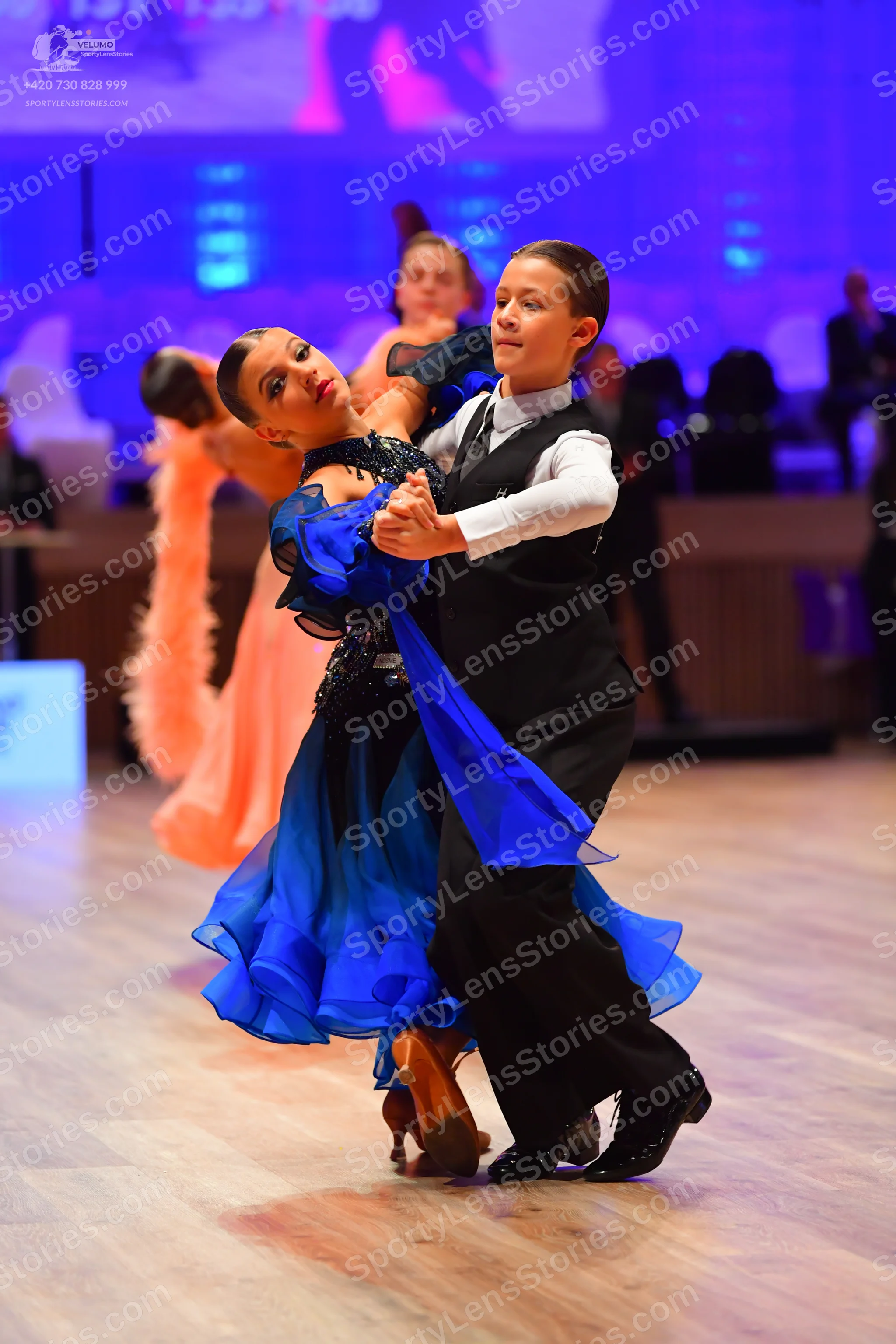 Dancesport competitor: Female dancer: royal blue ballroom dress with a black sequined bodice and a flow