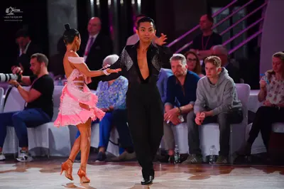 Dancesport competitor: Female dancer: light pink Latin dress with a ruffled, layered skirt
