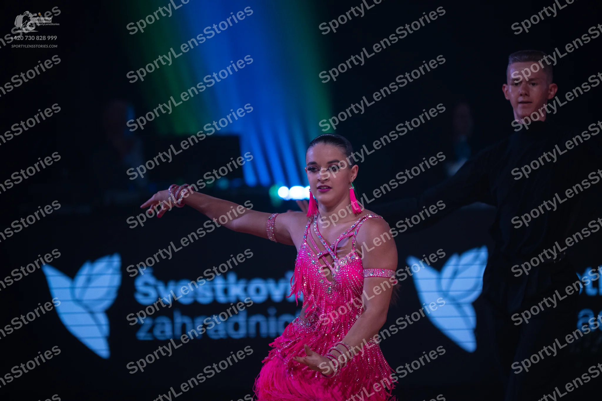 Dancesport competitor: Female dancer: bright pink Latin dance dress with sequins and fringe, and matchi