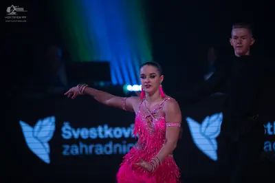 Dancesport competitor: Female dancer: bright pink Latin dance dress with sequins and fringe, and matchi