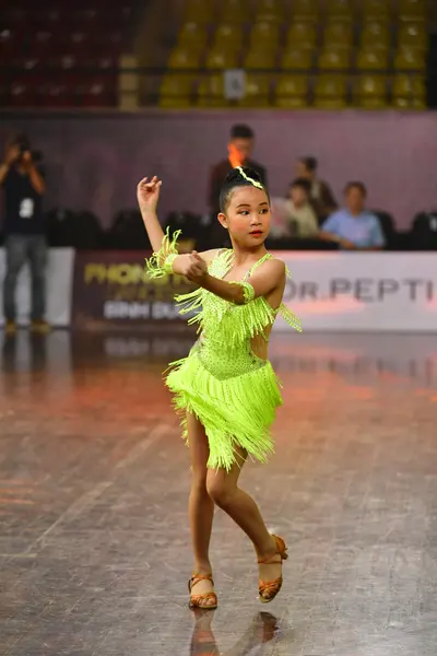 Dancesport competitor: Female dancer: lime green Latin dress with fringe