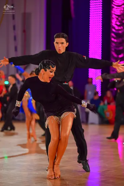 Dancesport competitor: Female dancer: black long-sleeved latin dance costume with silver sequin embelli
