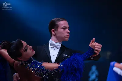 Dancesport competitor: Male dancer: black tuxedo with a white shirt and white bow tie