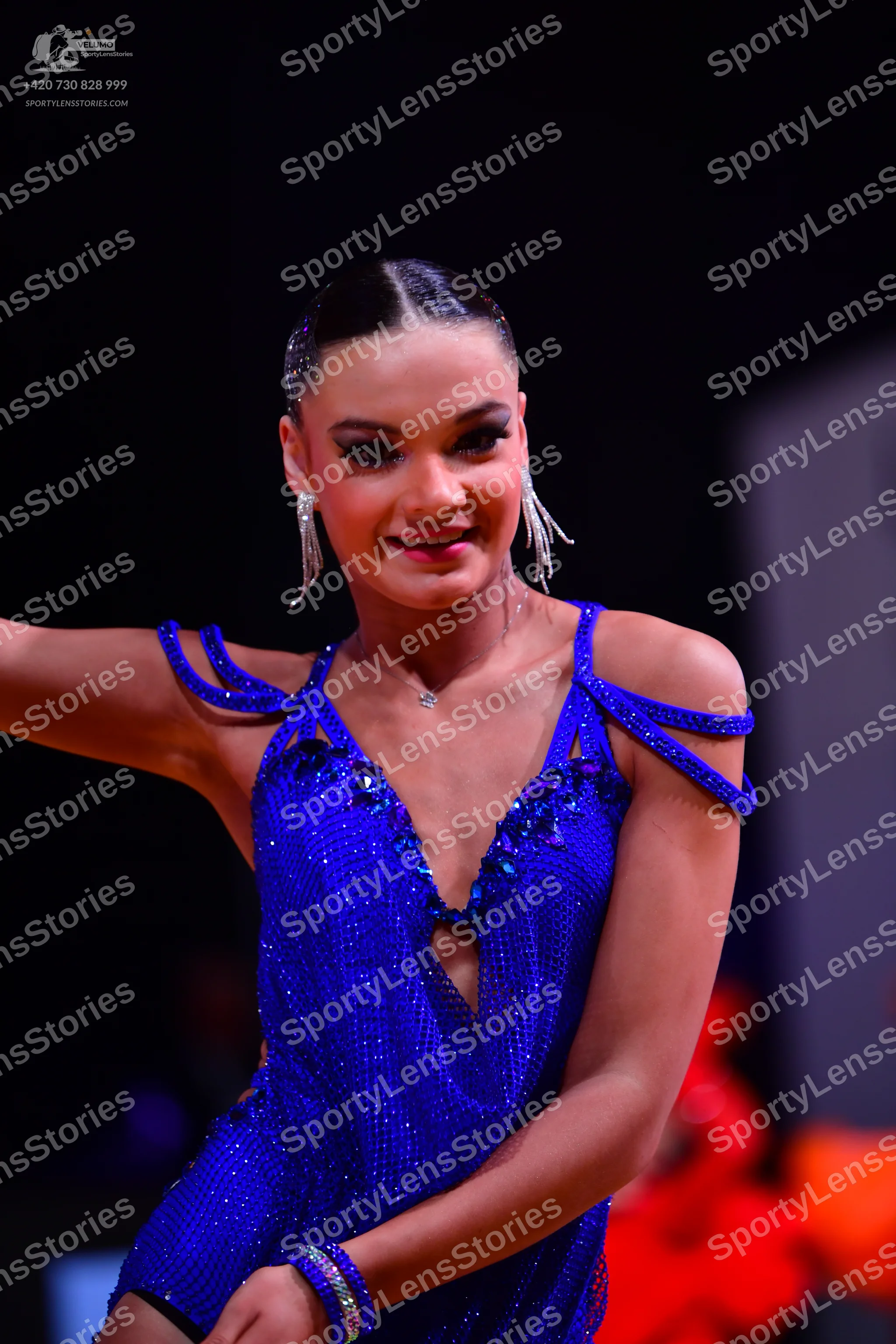 Dancesport competitor: Female dancer: blue sequined latin dress with thin embellished straps, silver ne