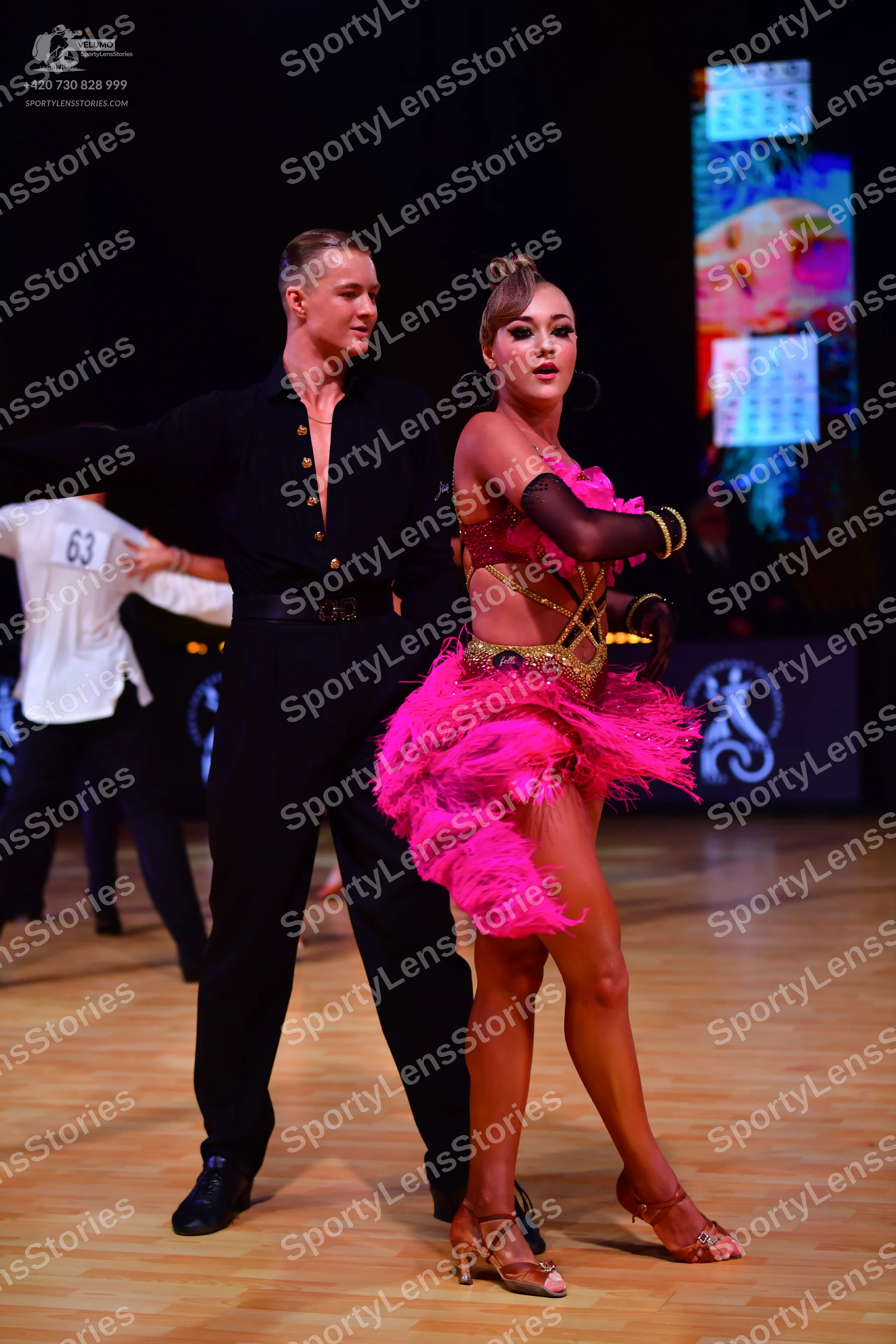 Dancesport competitor: Male dancer: black long-sleeved button-down shirt with gold buttons and black tr