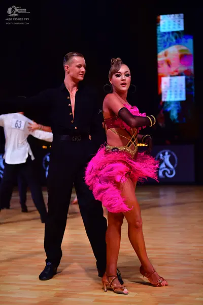 Dancesport competitor: Male dancer: black long-sleeved button-down shirt with gold buttons and black tr