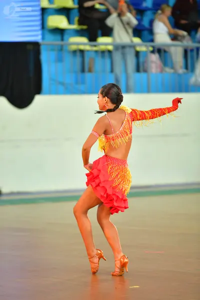 Dancesport competitor: ** Female: Red latin dress with fringe