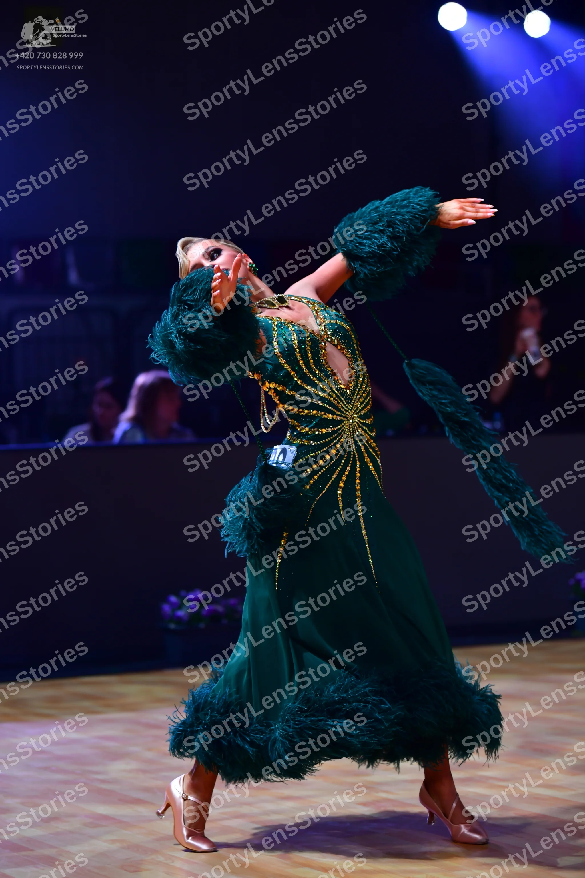 Dancesport competitor: Female dancer: emerald green ballgown with gold/yellow sequin/beadwork in a radi