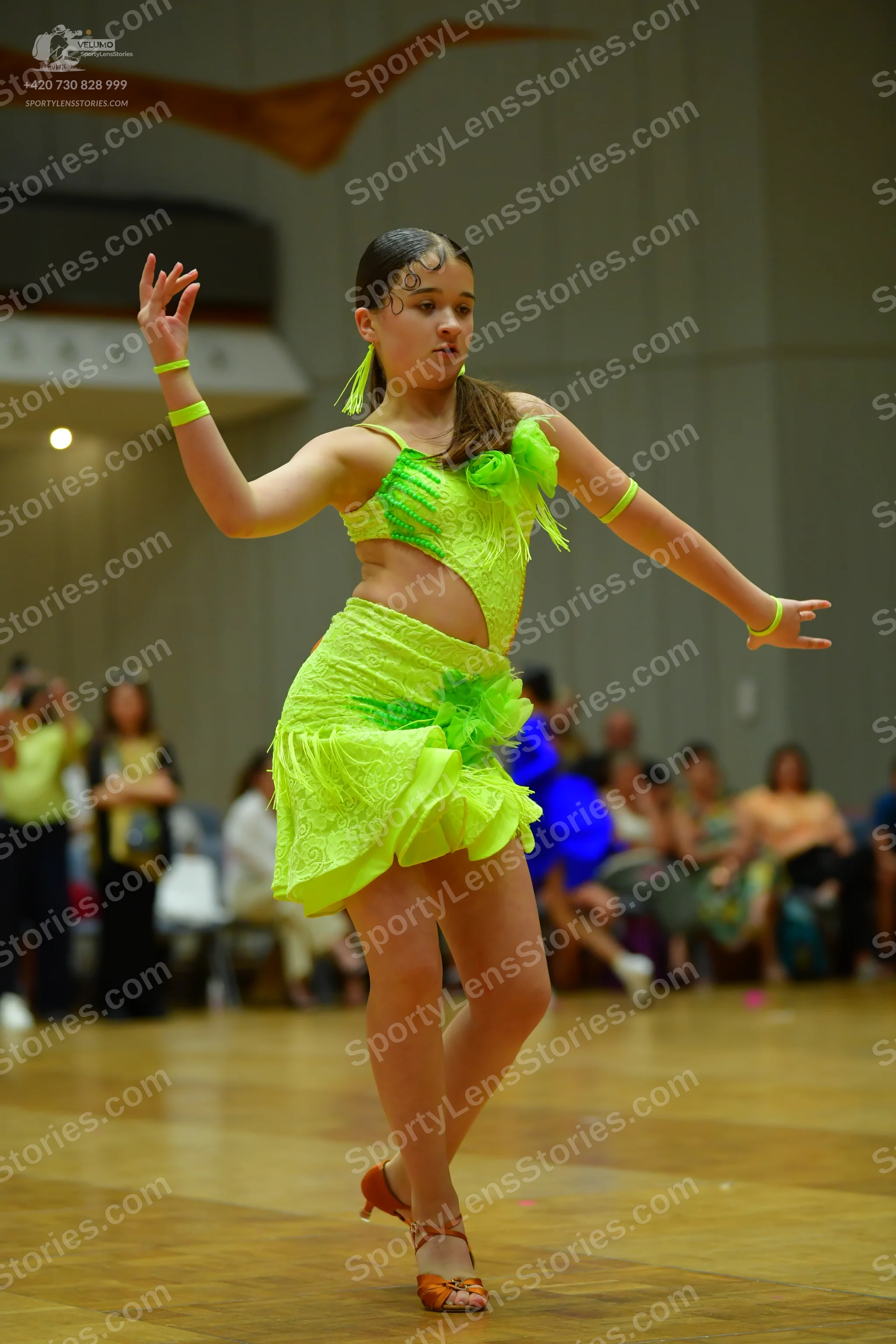 Dancesport competitor: Female dancer: neon green latin dance dress with textured fabric and ruffled det