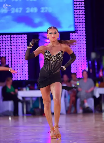Dancesport competitor: Female dancer: black latin dress with silver/white sequin patterns on the bodice
