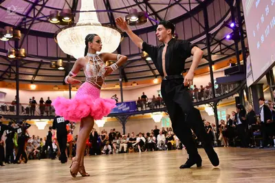 Dancesport competitor #142: Female dancer: white and silver lace bodice with a voluminous, ruffled bright pi