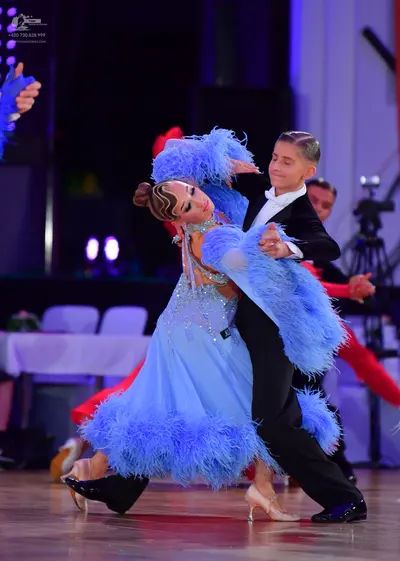 Dancesport competitor: Female dancer: light blue latin dress featuring sequins and large, voluminous bl