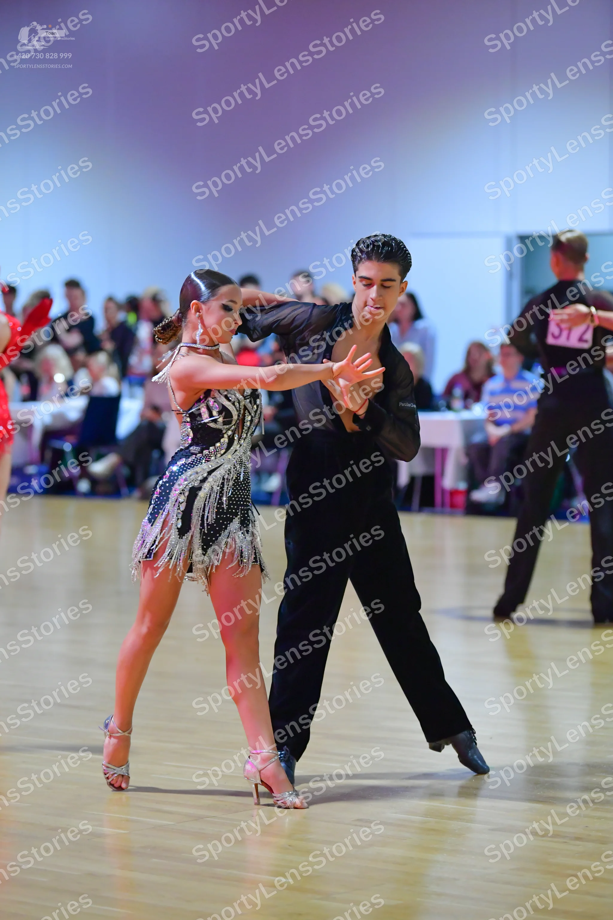 Dancesport competitor #312: Female dancer in foreground: black latin dress with silver sequin patterns and b