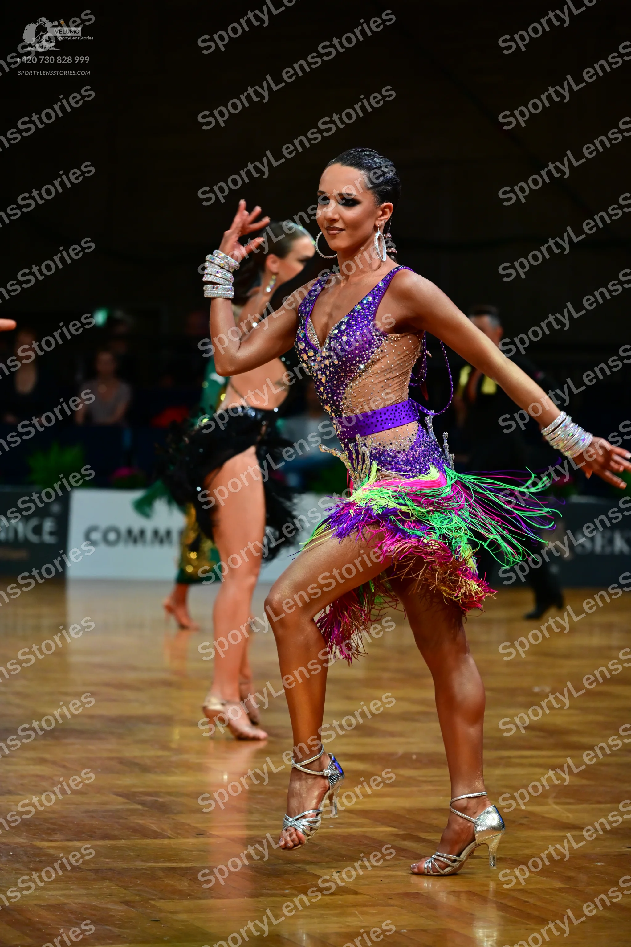 Dancesport competitor: Female dancer 1: purple, green, and pink latin dress with sequins and long fring