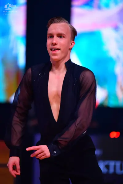 Dancesport competitor: Male dancer: black long-sleeved shirt with sheer sleeves and a deep V-neckline, 