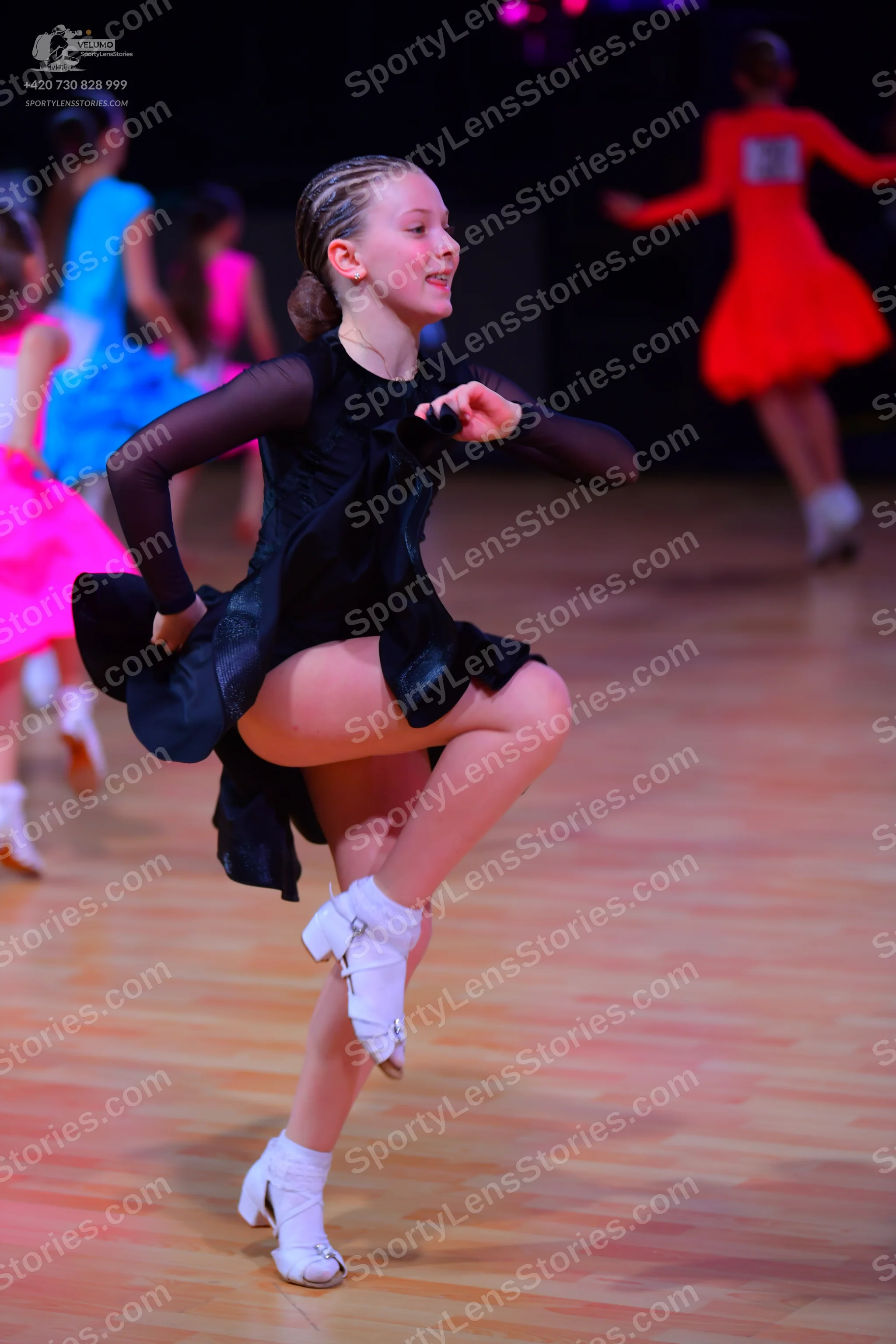 Dancesport competitor: Main dancer: black latin dress with long, sheer sleeves and sequin details on th