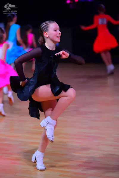 Dancesport competitor: Main dancer: black latin dress with long, sheer sleeves and sequin details on th