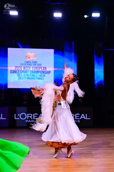 Dancesport competitor: Female dancer: white ballroom gown with large white feather trim on the shoulder