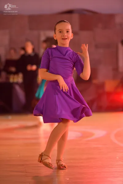 Dancesport competitor: Female dancer: purple short-sleeved dress with a smooth, satin-like fabric and a