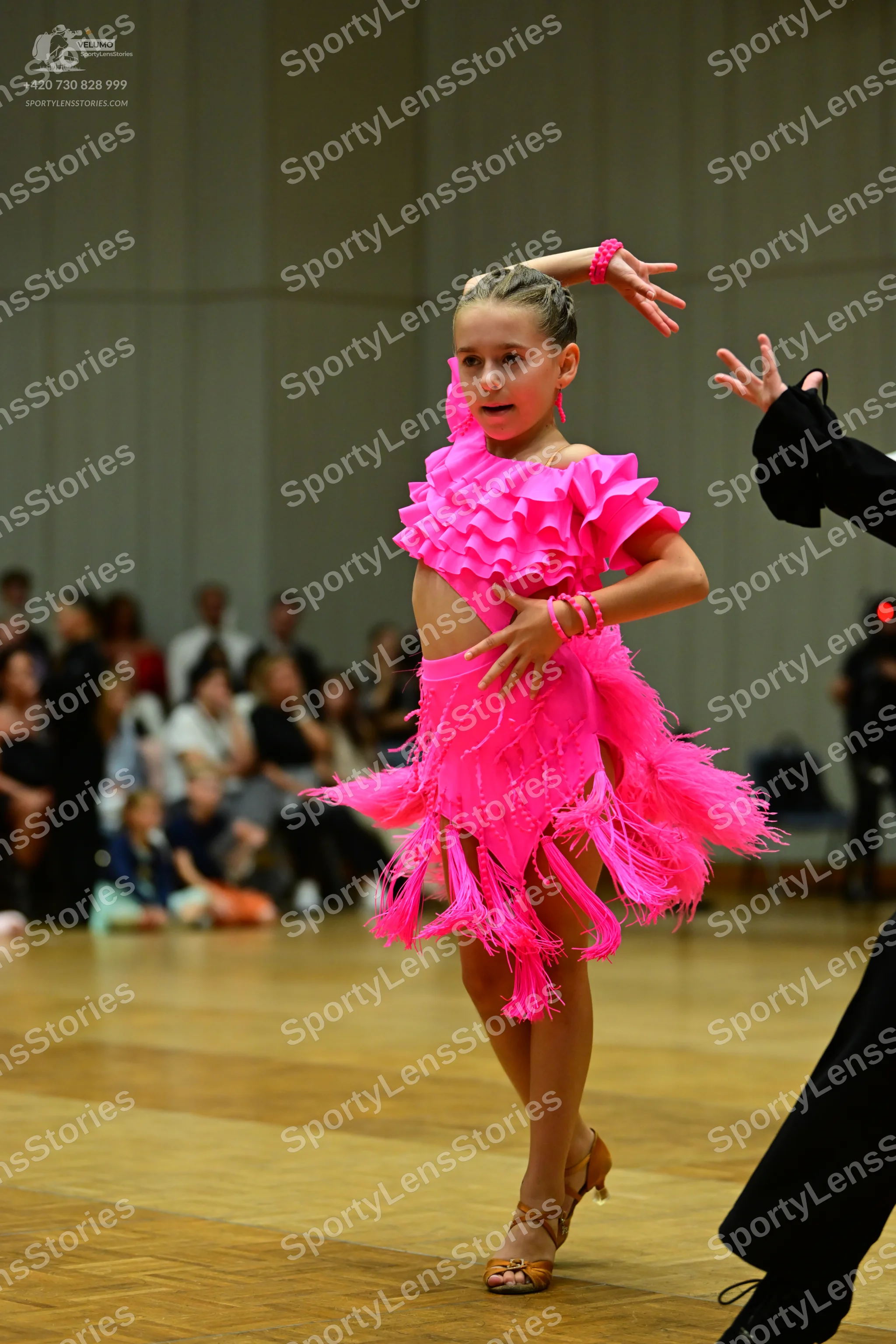 Dancesport competitor: Female dancer: bright pink Latin dance dress with layers of fringe and ruffles, 