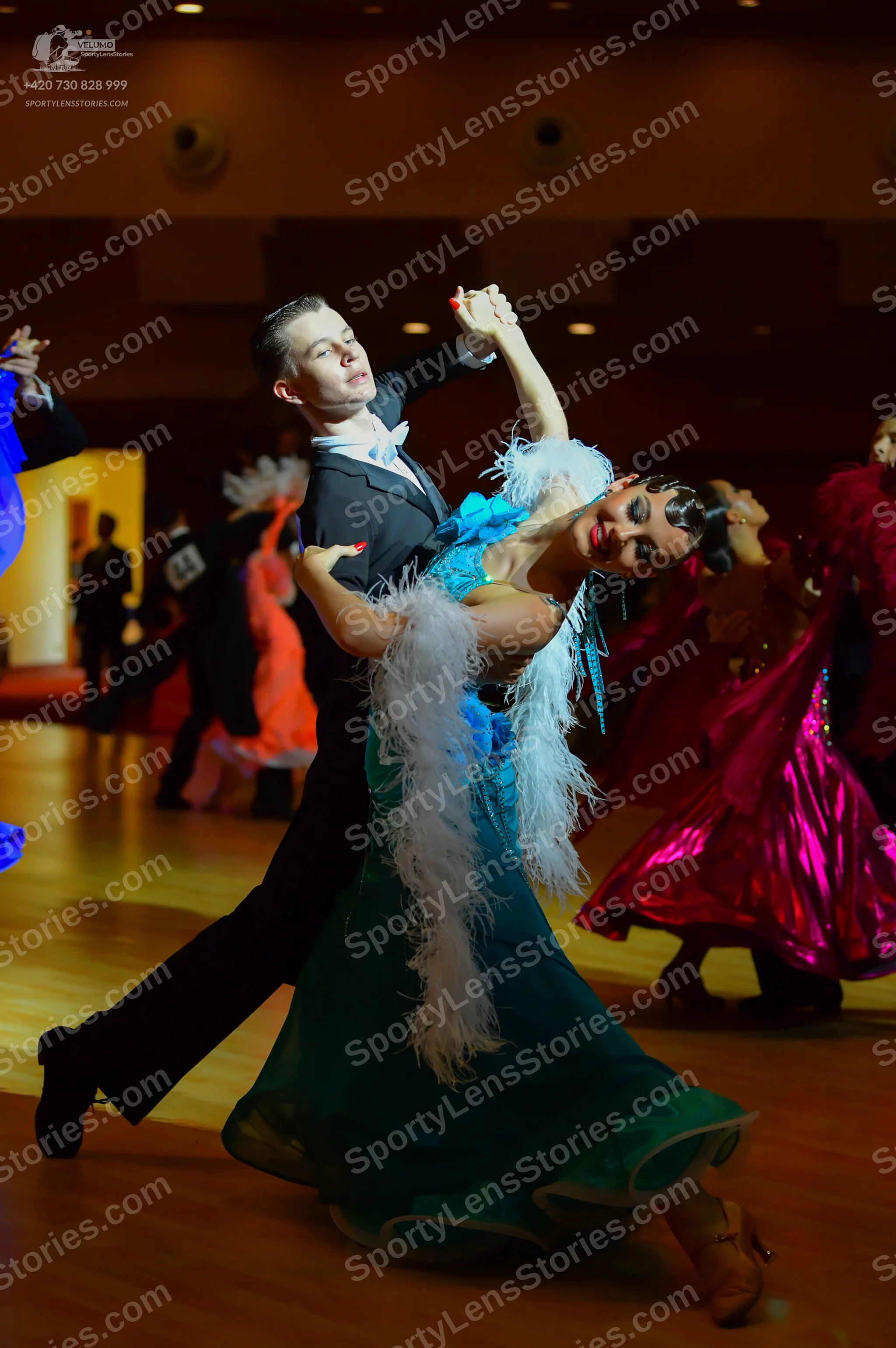 Dancesport competitor #64: Main female dancer: teal/aqua ballgown with a large white feather boa