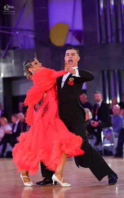 Dancesport competitor: Female dancer: coral-colored Latin dress with long, layered fringe