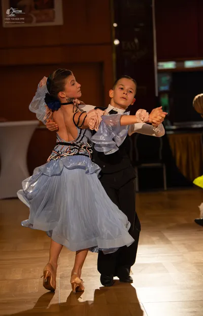 Dancesport competitor: Male dancer: black waistcoat over a white long-sleeved shirt and black trousers
