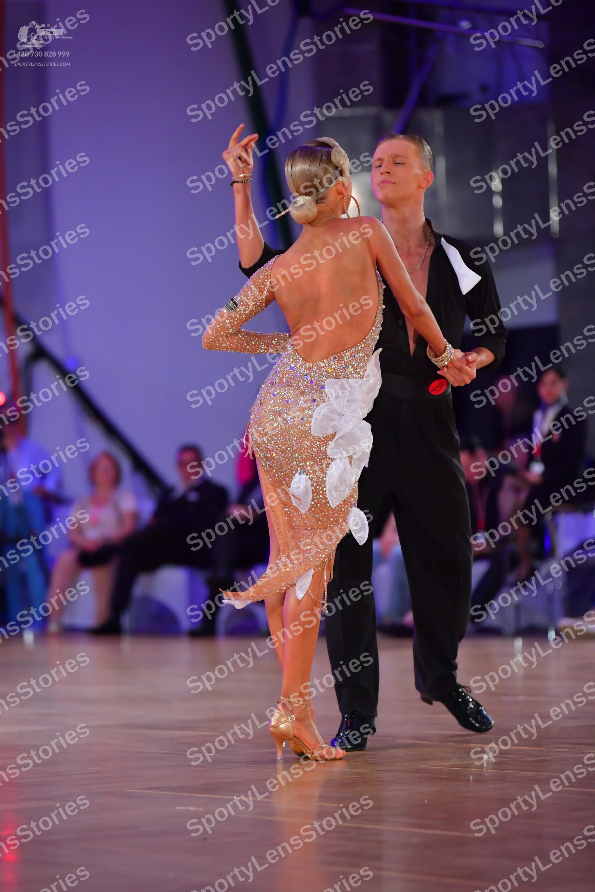 Dancesport competitor: Female dancer: nude-colored Latin dress with sequins and large white fabric peta