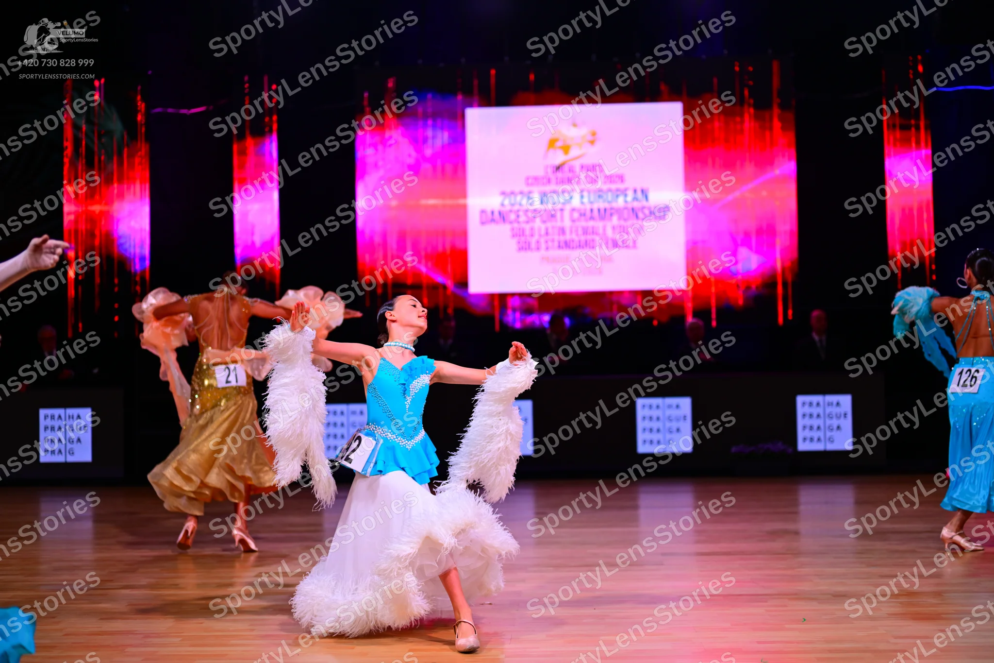 Dancesport competitor: Female dancer on the left: gold Latin dress with a ruffled skirt