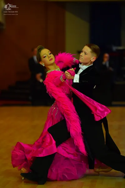 Dancesport competitor: Female dancer: bright pink ballroom dress with a voluminous ruffled skirt, pink 
