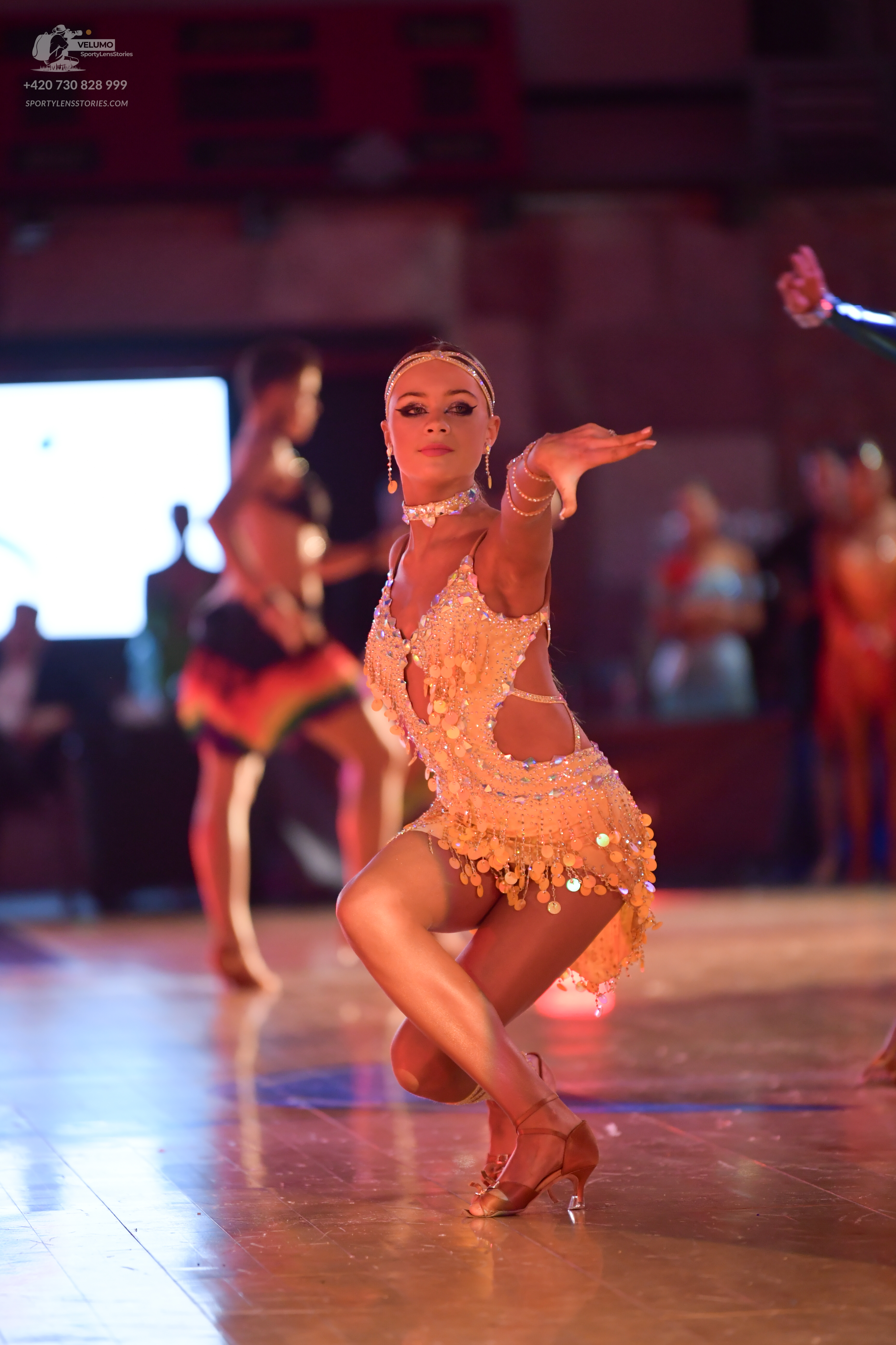 Dancesport competitor: Female dancer: champagne-colored Latin dance dress, heavily embellished with seq