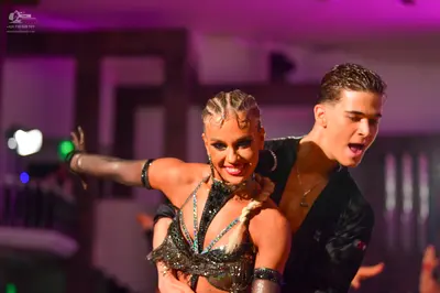 Dancesport competitor: Female dancer: black Latin dance costume with heavy sequin and rhinestone embell