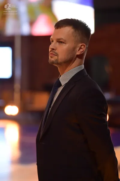 Dancesport competitor: Man: dark suit with a light-colored, micro-patterned shirt