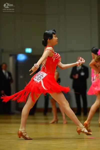 Dancesport competitor #556: Female dancer in foreground: red latin dress with fringe