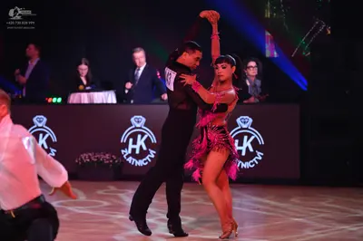 Dancesport competitor: Male dancer (center): black long-sleeved shirt and black trousers