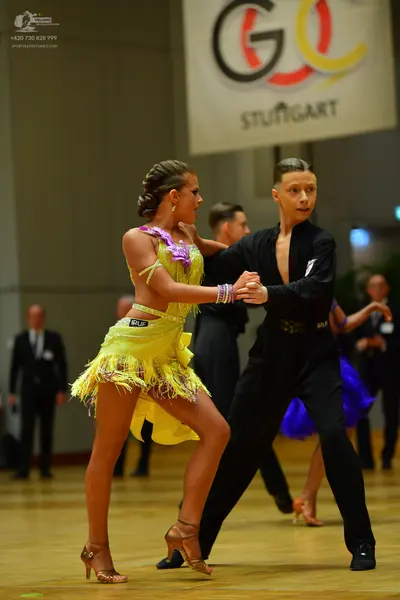 Dancesport competitor: Female dancer: yellow Latin dance dress with purple/lavender sequined embellishm