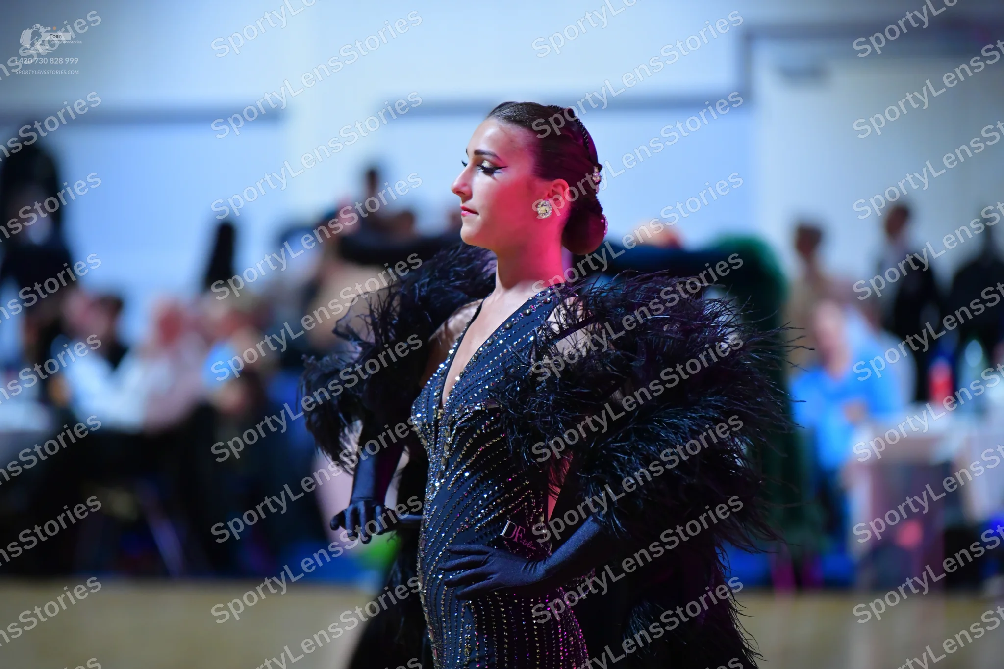 Dancesport competitor: Female dancer: black sequined dress with a deep V-neckline, large voluminous fea