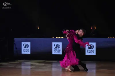 Dancesport competitor: Female dancer: bright pink/magenta Latin dance dress with layered fabric or frin