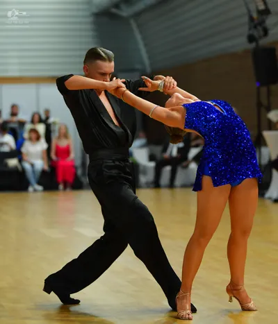 Dancesport competitor: **
*   **Male Dancer:** Black tail suit with a subtle sequin pattern on the lape