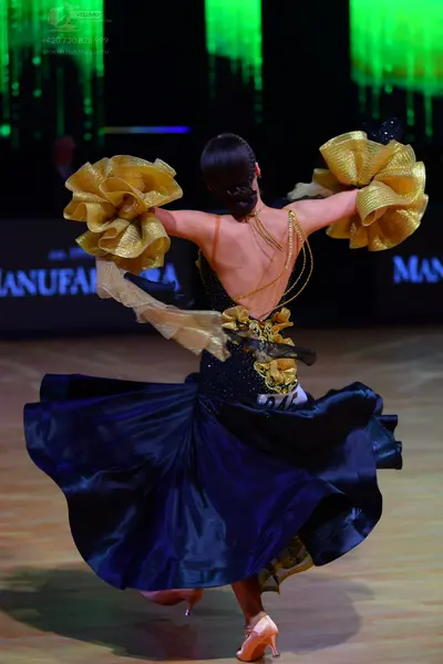 Dancesport competitor: Female dancer: Navy blue ballgown with voluminous satin skirt, featuring large g