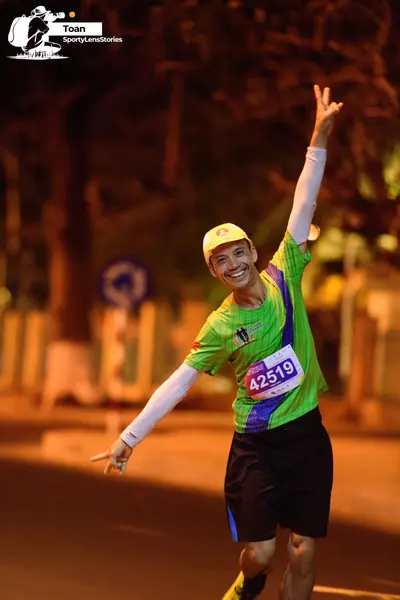 Marathon runner #42519: Runner 1: lime green jersey with blue accents, black shorts, yellow cap, white a