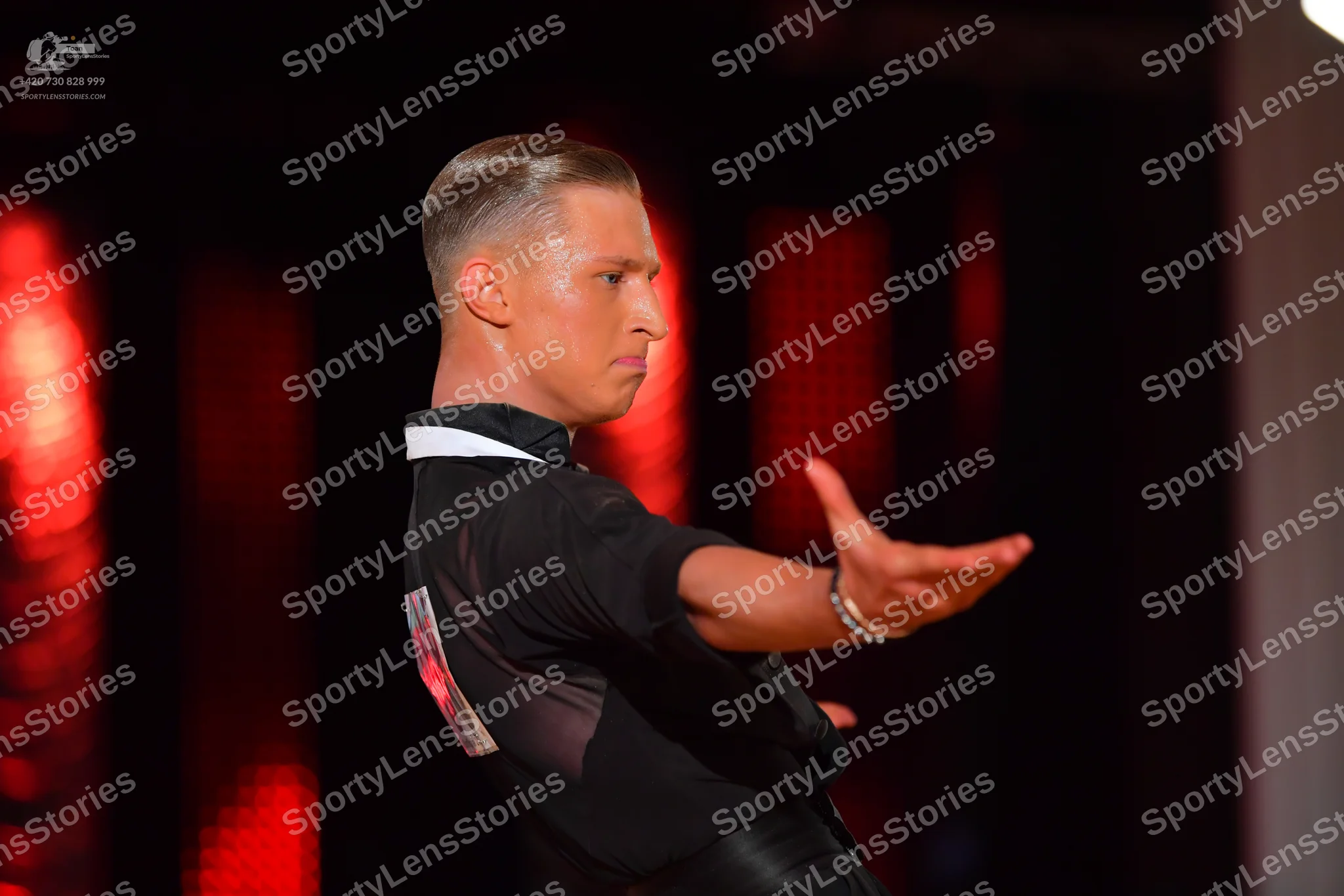 Dancesport competitor: Male dancer: black short-sleeved shirt with a white collar, black trousers, and 