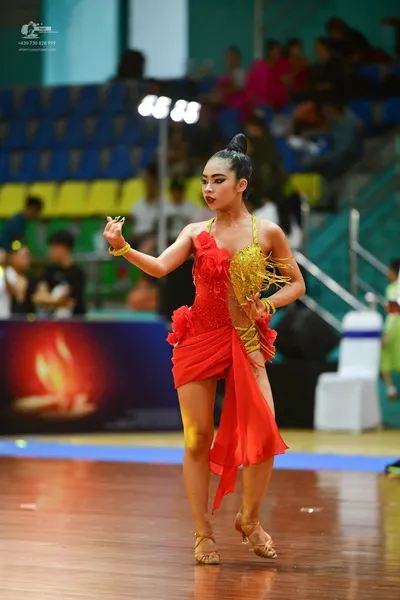Dancesport competitor: ** Female: Red Latin Dress - The dancer is wearing a vibrant red Latin dress