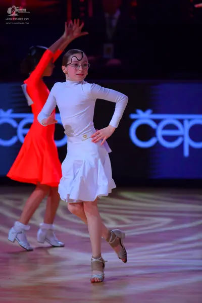 Dancesport competitor: Female dancer 1: white long-sleeved latin dress with a flared skirt