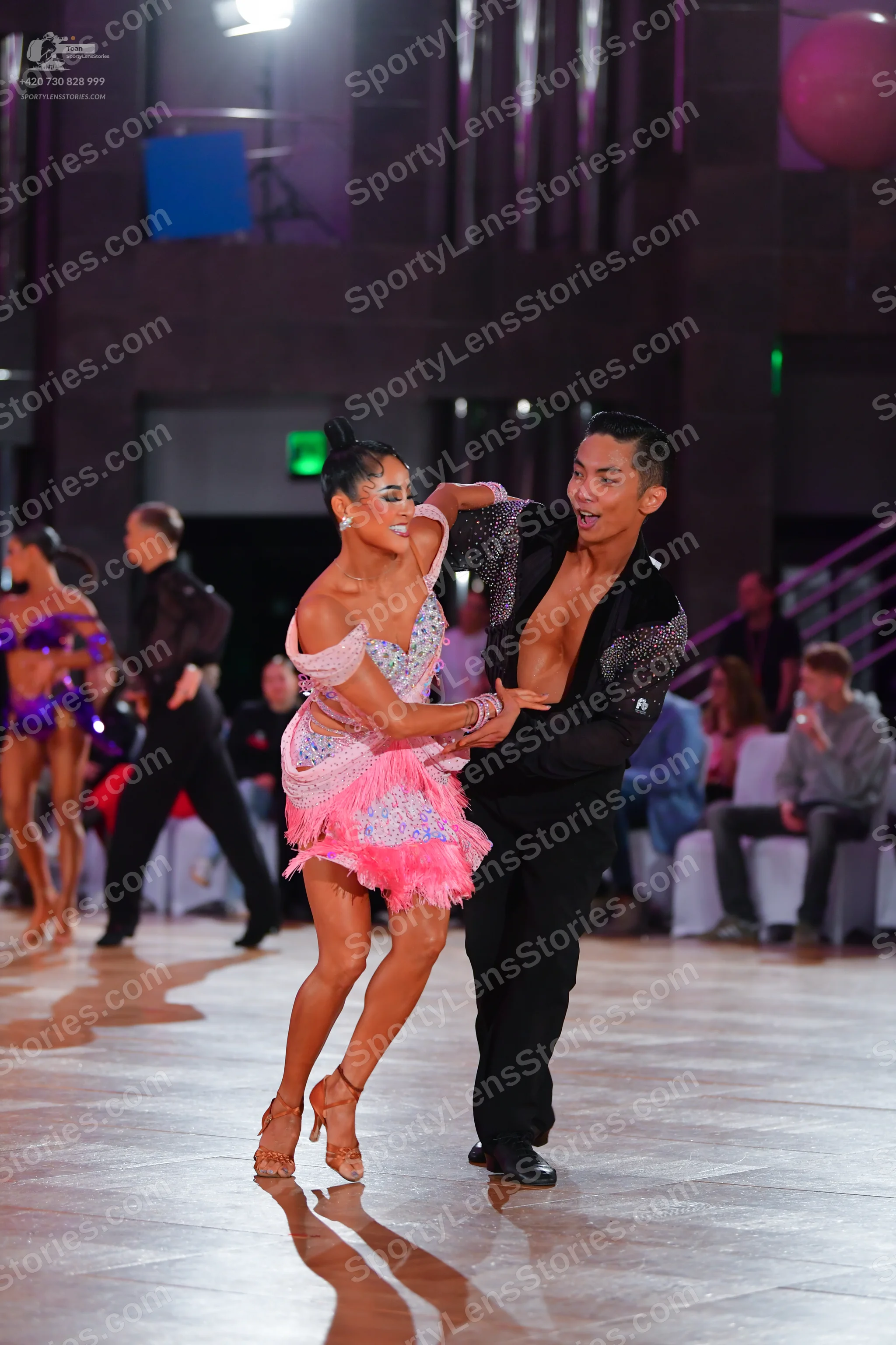 Dancesport competitor: Main female dancer: pink latin dress with sequins and a layered skirt, paired wi